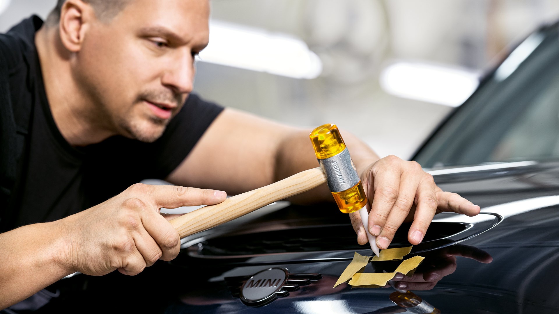 Tæknimaður lagfærir dæld á yfirbyggingu MINI